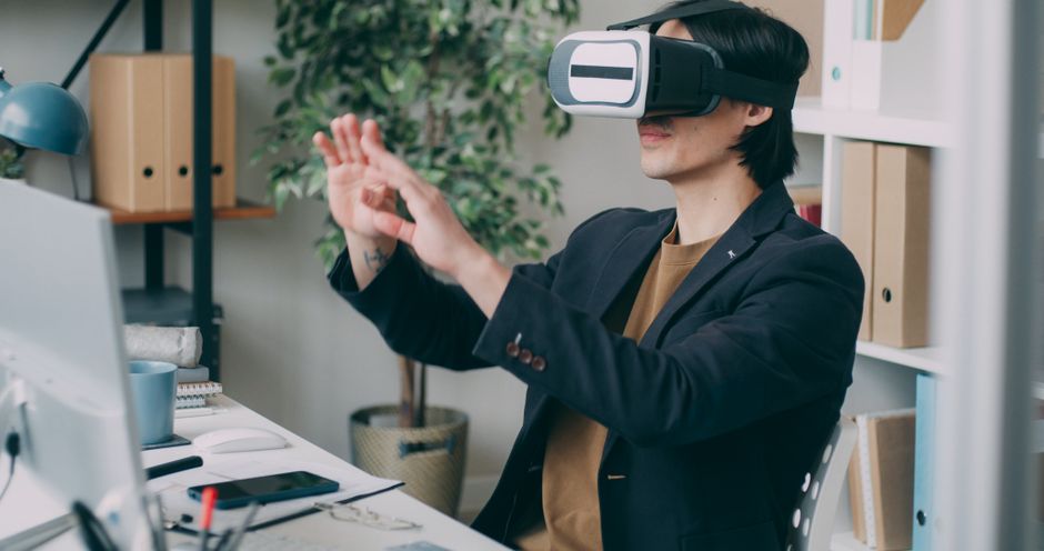 Čovjek u uredskom okruženju koristi VR headset za rad na projektu